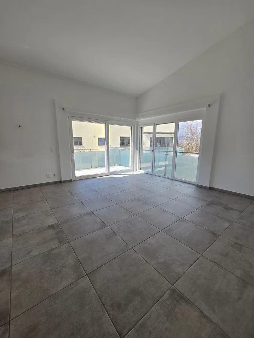 Leerer, heller Wohnraum mit Balkon
