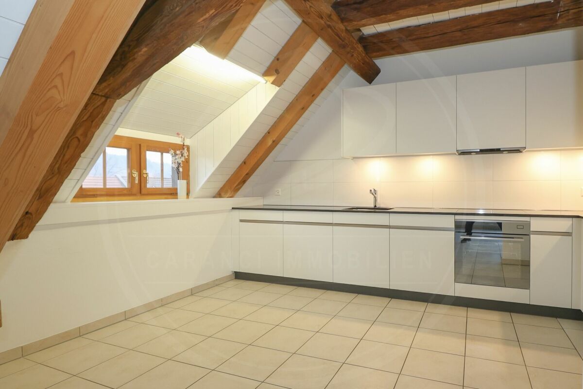 Dachgeschossküche mit sichtbaren Holzbalken