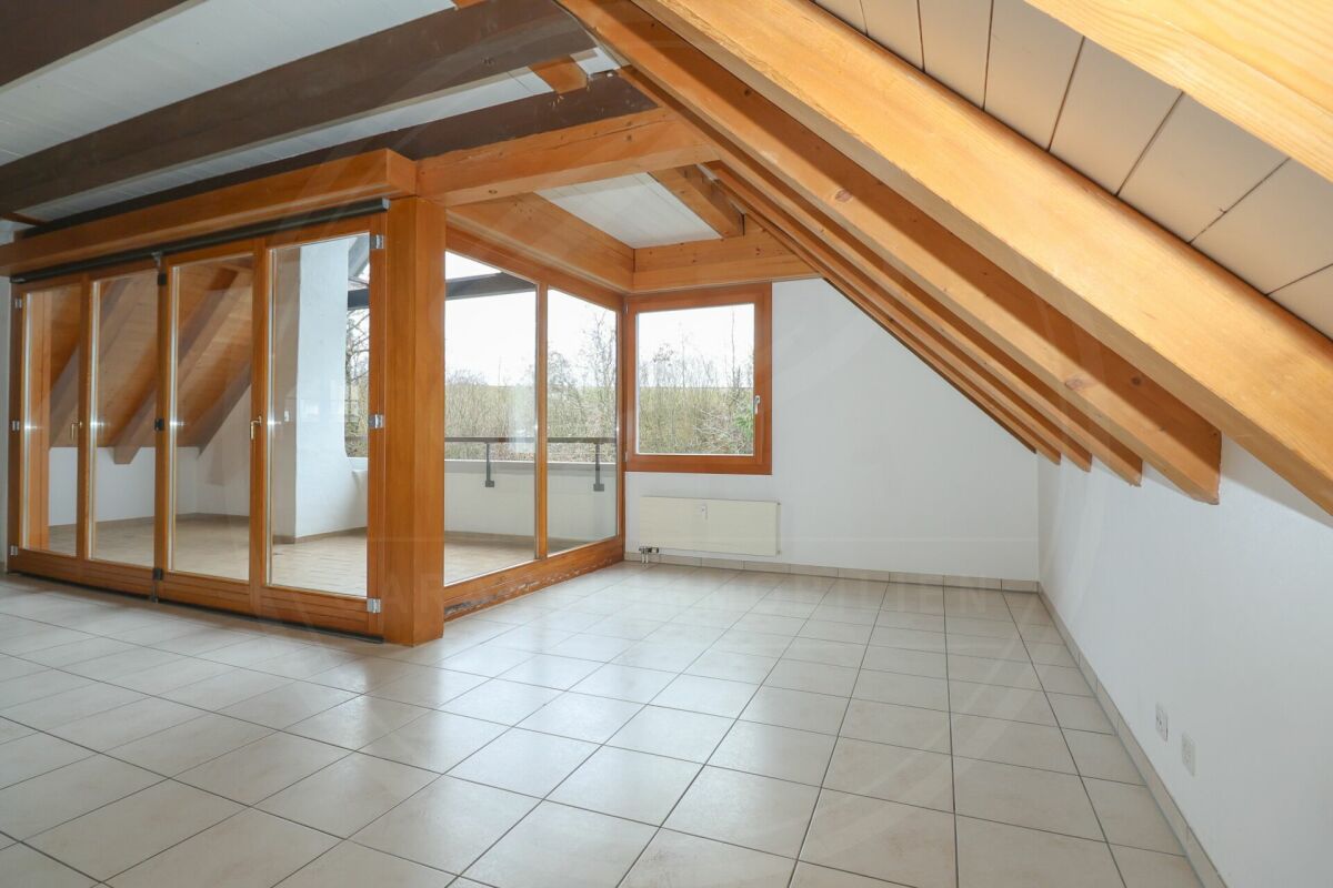 Dachgeschossraum mit Balkon und Holzsparren