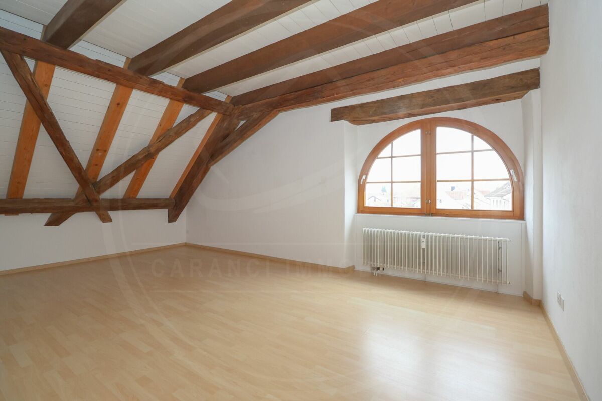 Dachgeschossraum mit sichtbaren Holzbalken