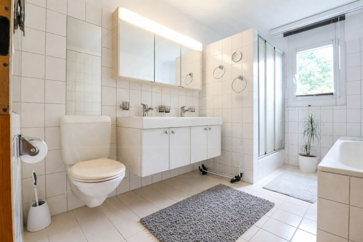 Helles Badezimmer mit Badewanne und Waschplatz