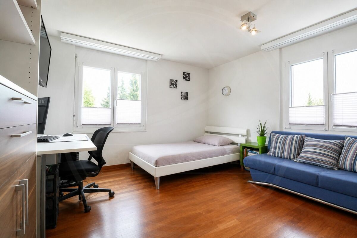 Helles Schlafzimmer mit Arbeitsbereich und Sofa