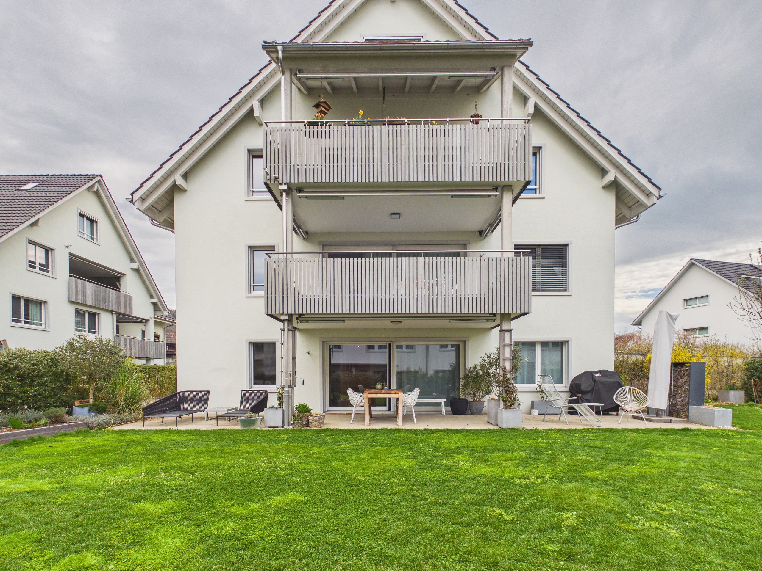 Gartenansicht eines modernen Einfamilienhauses mit Balkonen