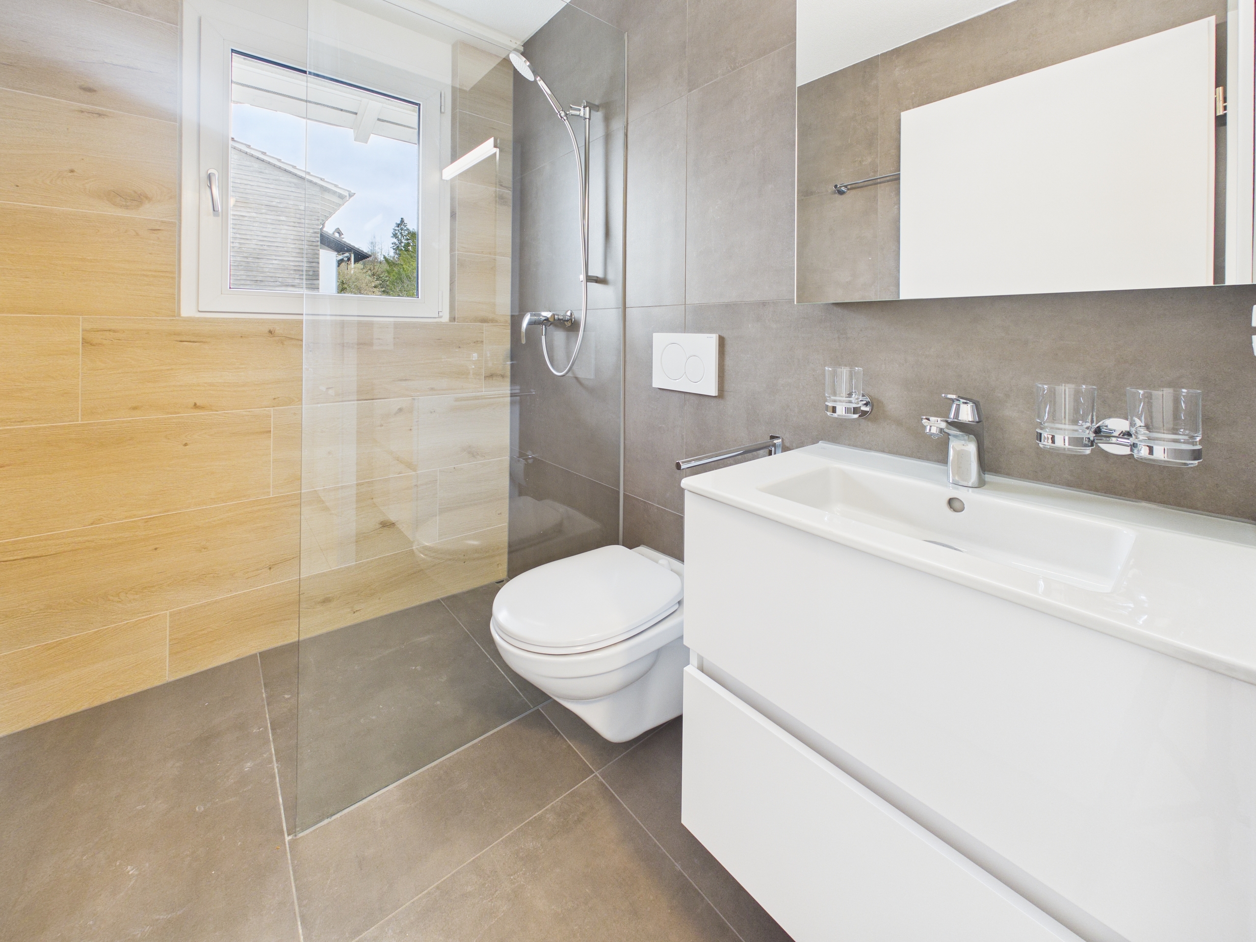 Modernes Bad mit Dusche und Waschtisch