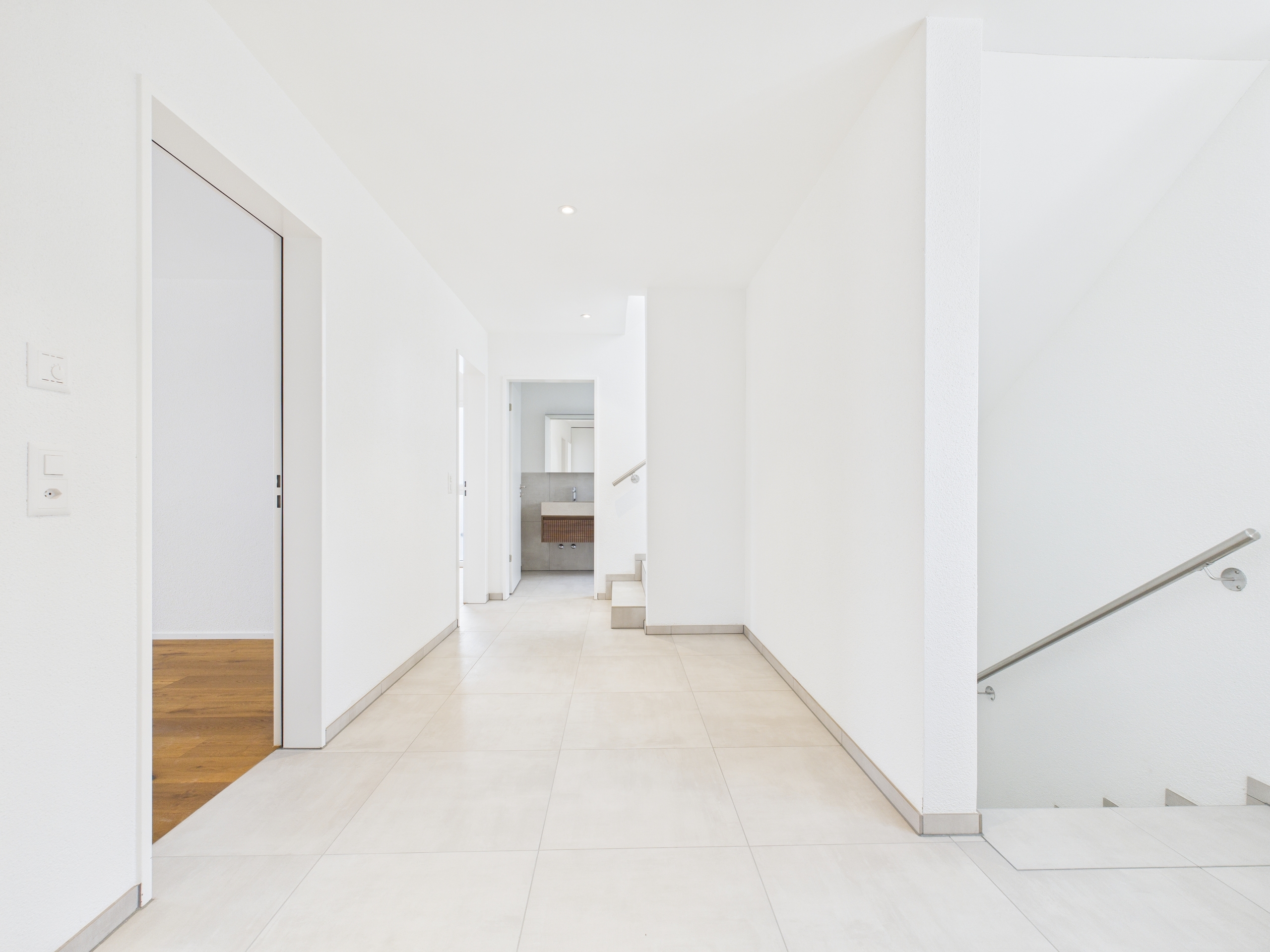 Heller Flur mit Treppe und Blick zum Waschbereich