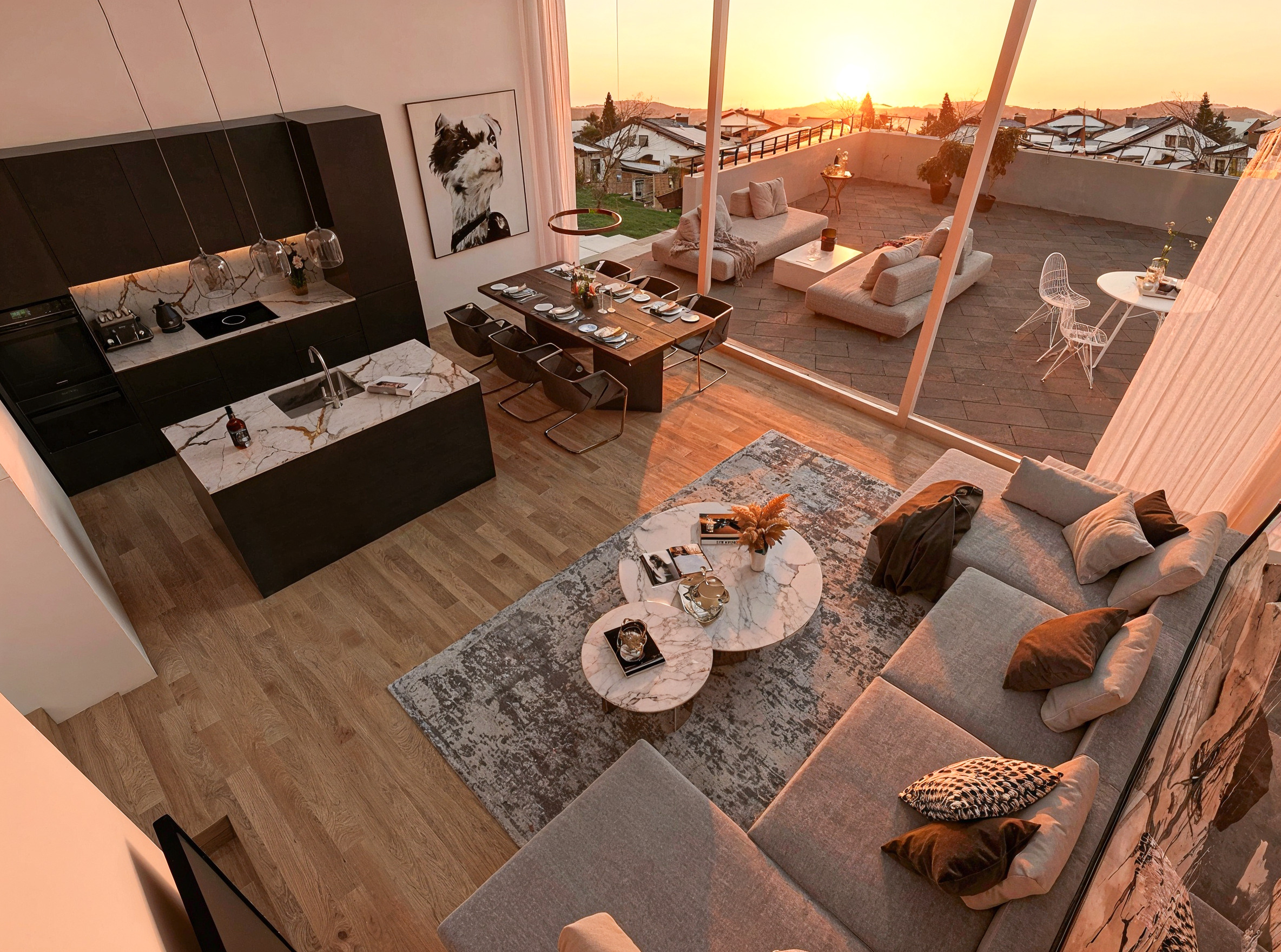 Offener Wohn-, Ess- und Küchenbereich mit Dachterrasse bei Sonnenuntergang