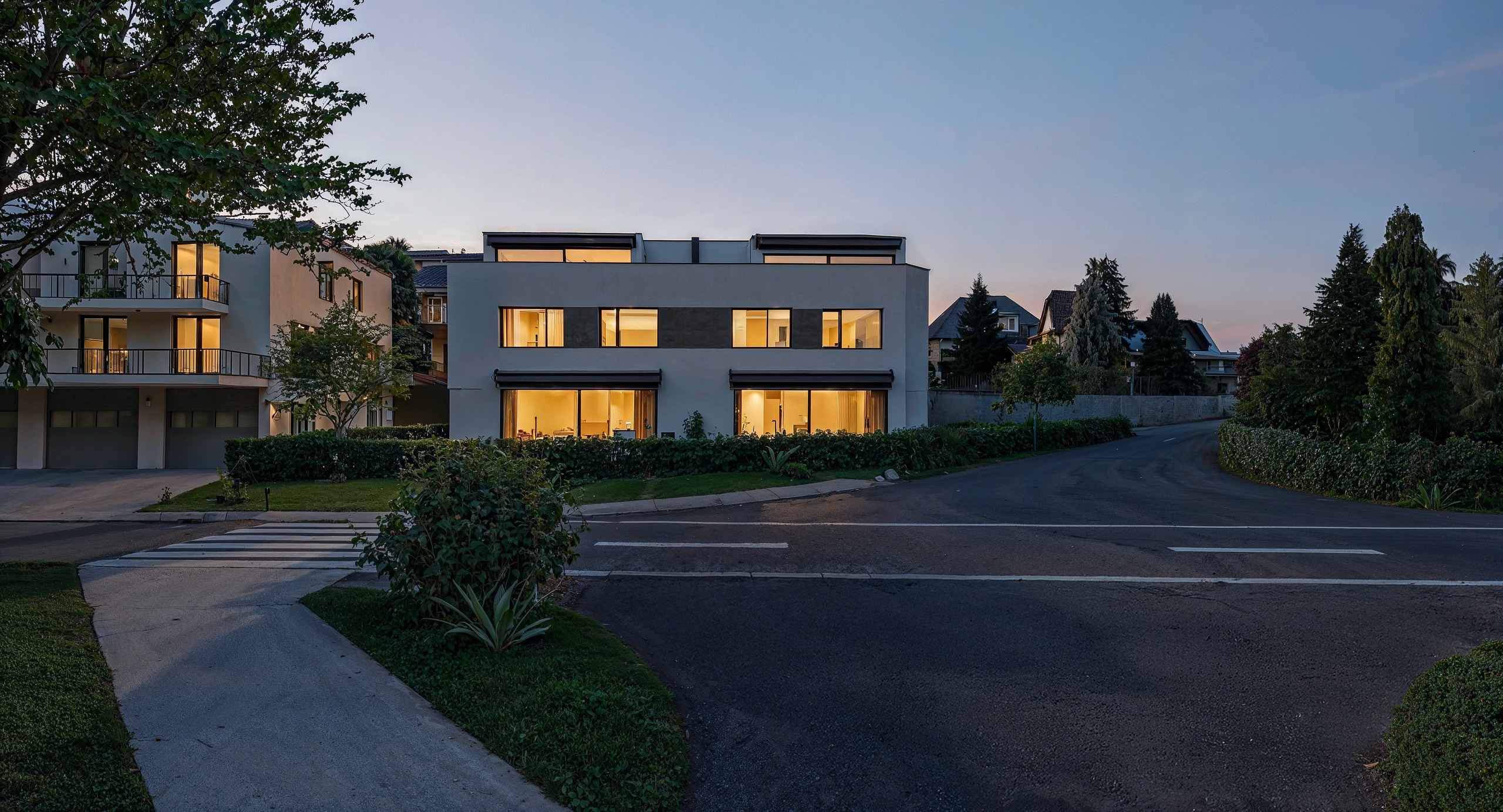 Moderne Wohnhäuser an einer ruhigen Straße bei Dämmerung