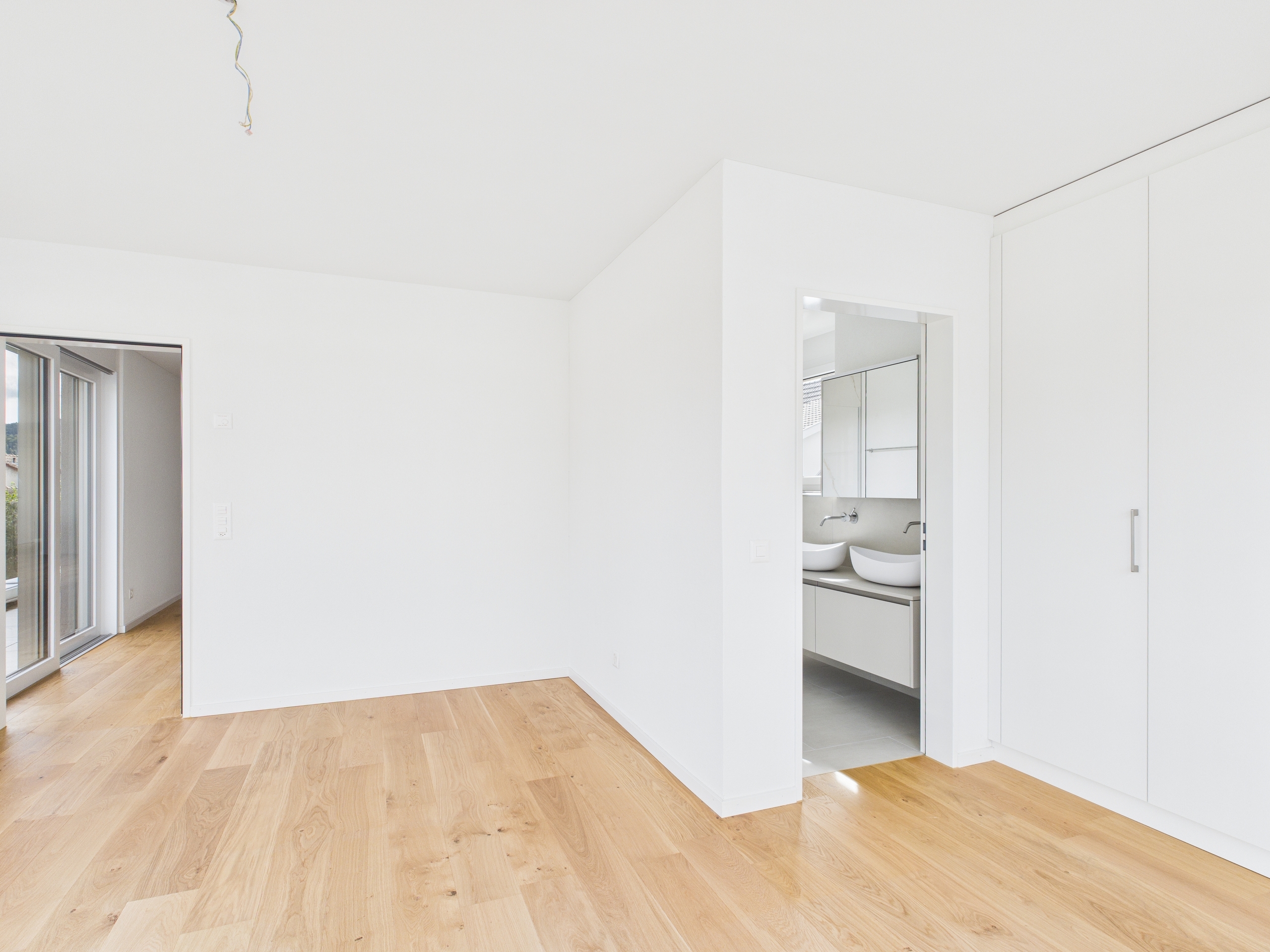 Helles leeres Schlafzimmer mit Ankleide und Badzugang
