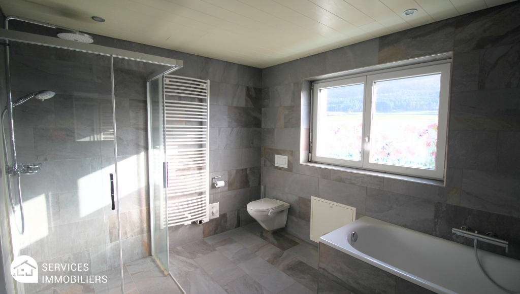 Modernes Badezimmer mit Dusche, Badewanne und Fenster