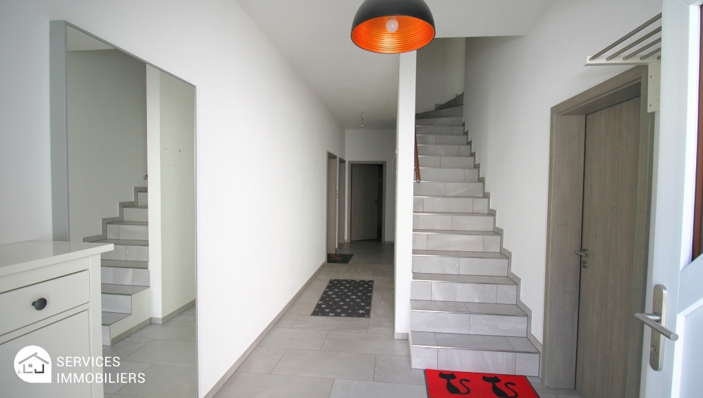 Heller Eingangsbereich mit Treppe und Spiegelwand