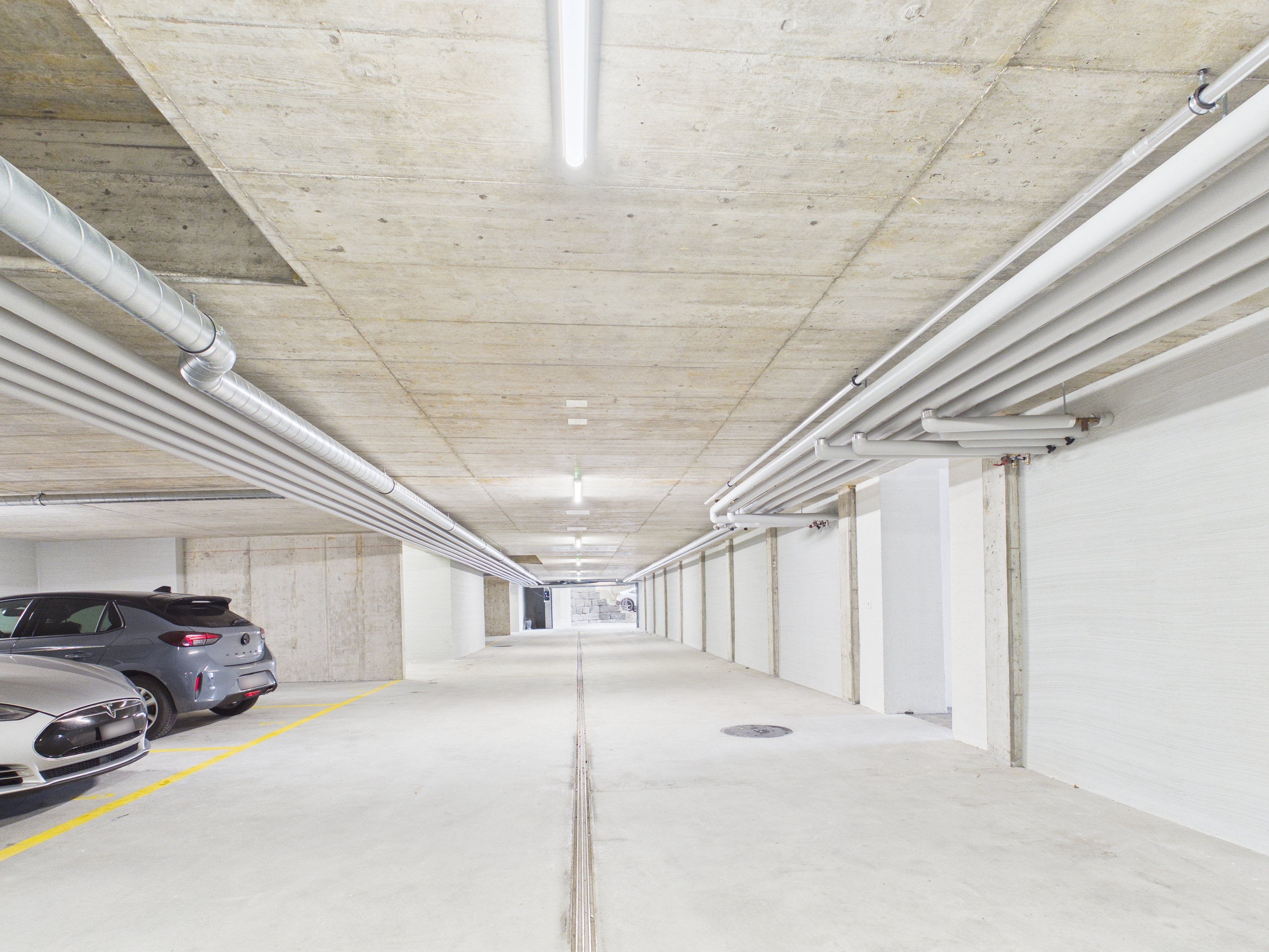 Tiefgarage mit Betonwänden und geparkten Autos