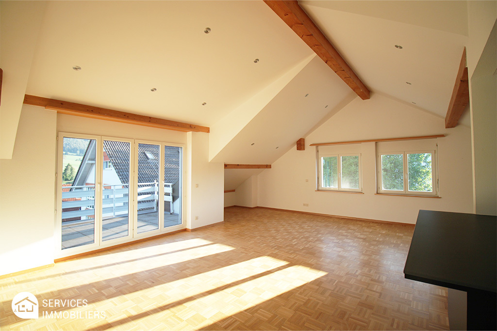 Heller Dachgeschossraum mit Balkon und Holzdeckelementen