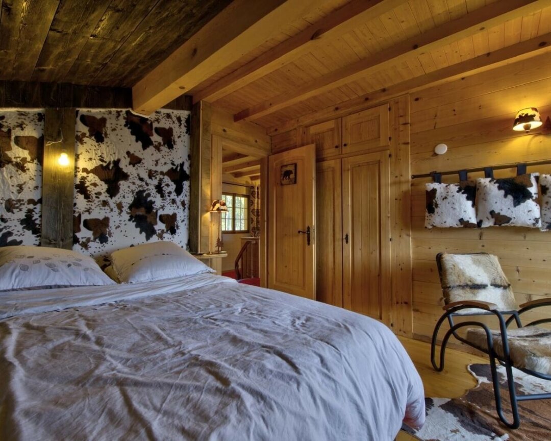 Rustikales Schlafzimmer mit Holzvertäfelung und Kuhfell-Akzenten