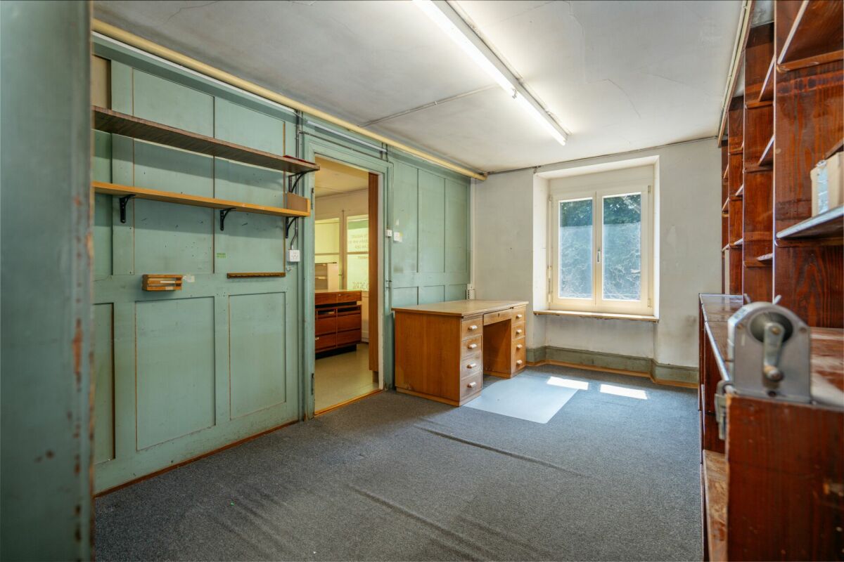 Renovierungsbedürftiger Arbeitsraum mit Fenster und Einbauregalen