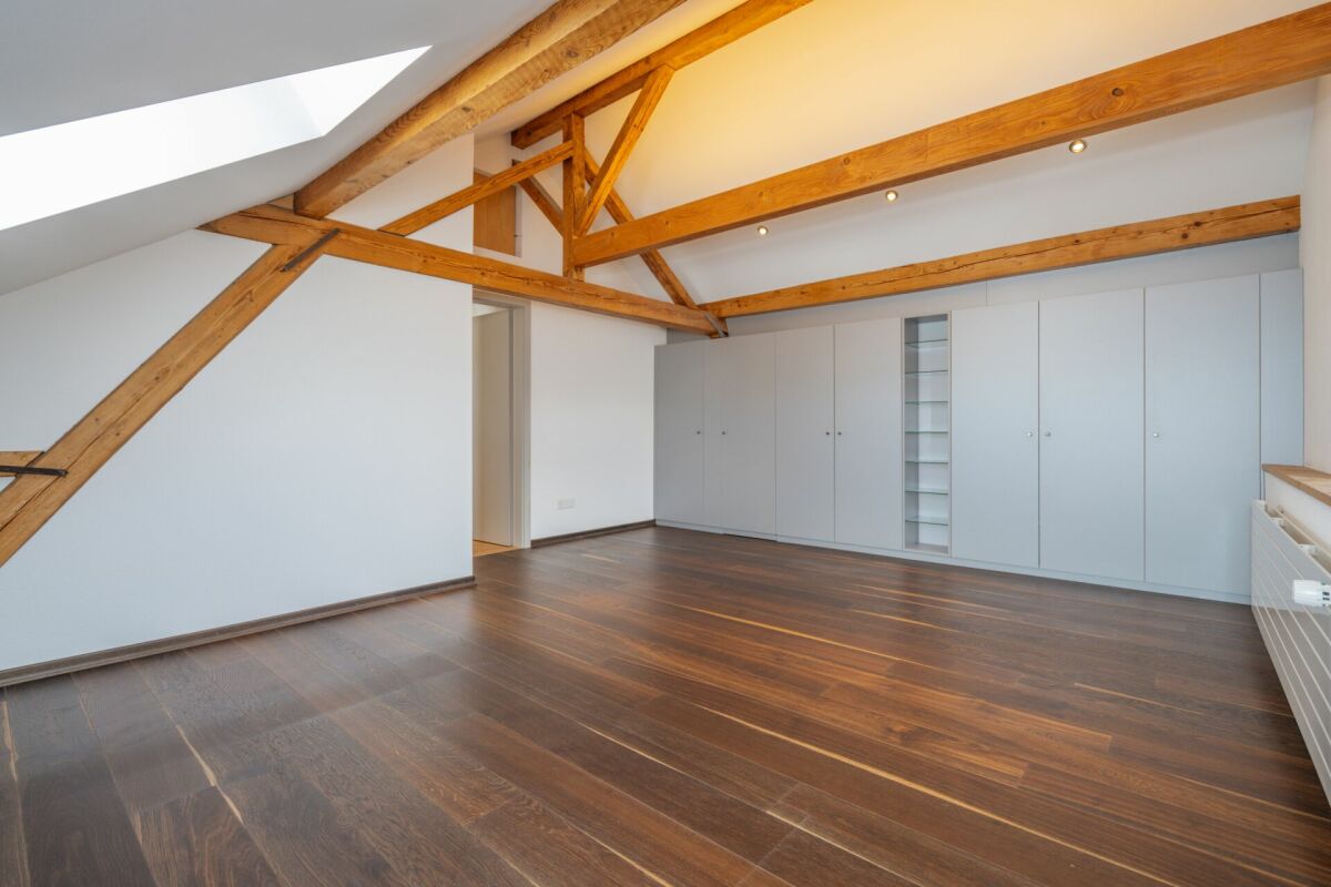 Dachgeschossraum mit sichtbaren Holzbalken