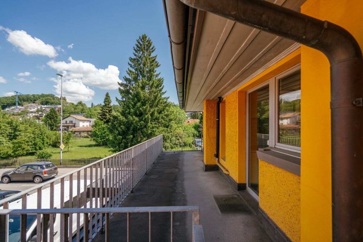 Außenbalkon mit Geländer und gelber Fassade