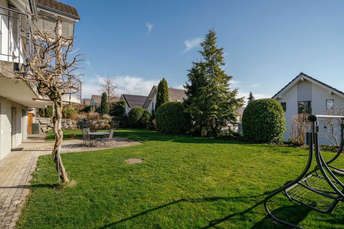 Gepflegter Garten mit Terrasse und Nachbarhäusern