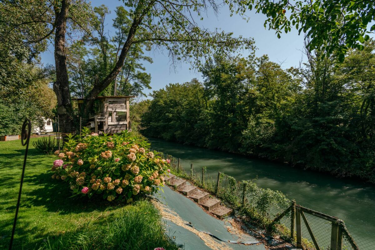 Flussufer mit Garten und kleinem Holzbau