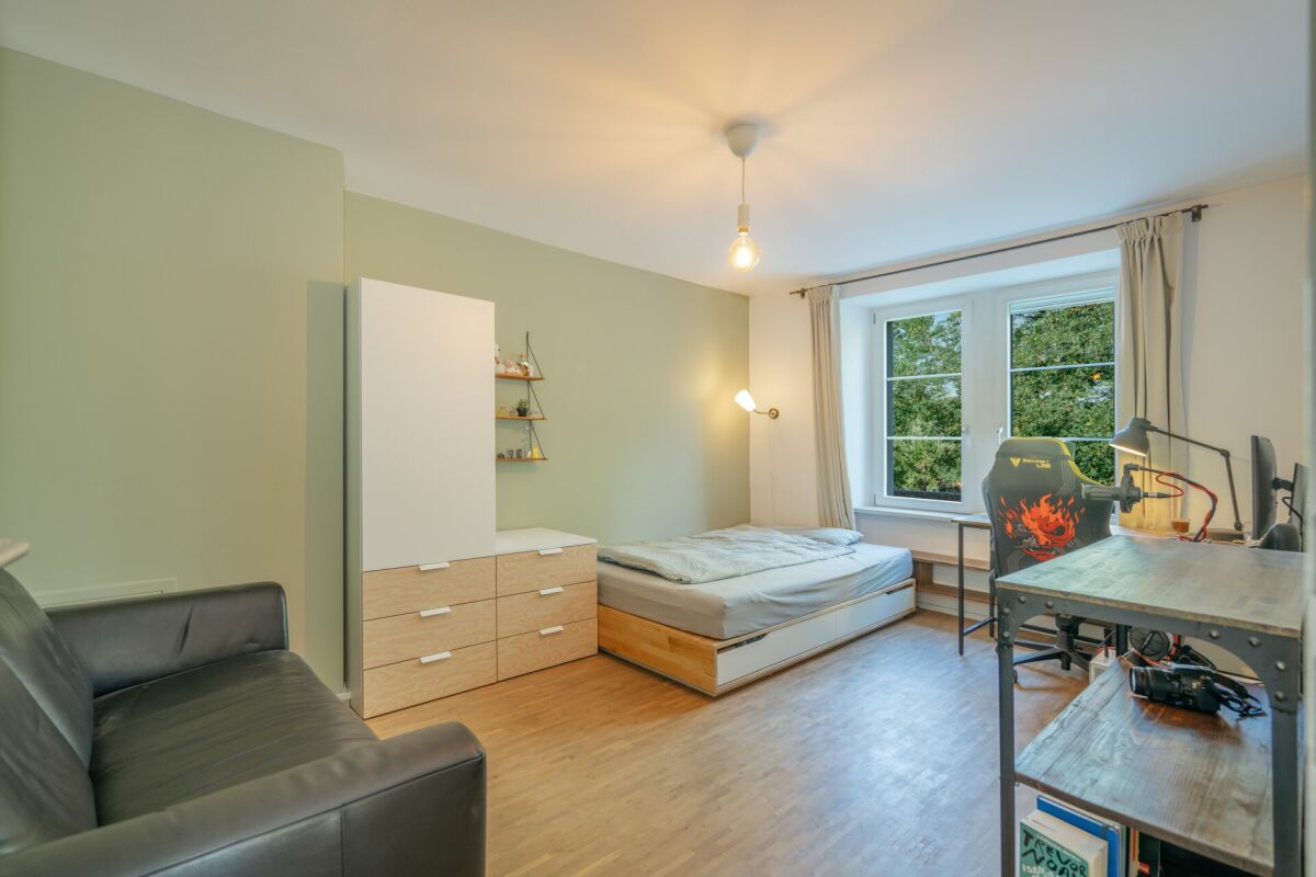 Helles Schlafzimmer mit Arbeitsplatz und Sofa