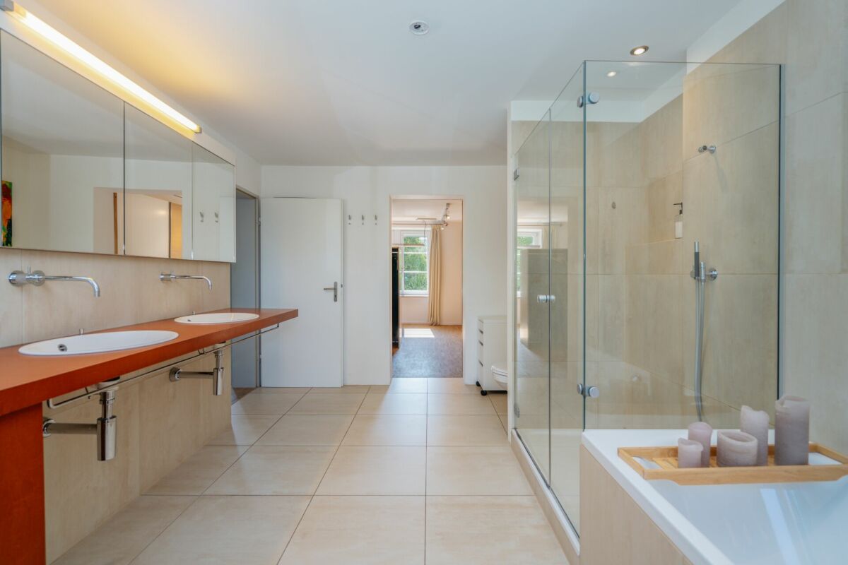 Modernes Badezimmer mit Doppelwaschtisch und Glasdusche