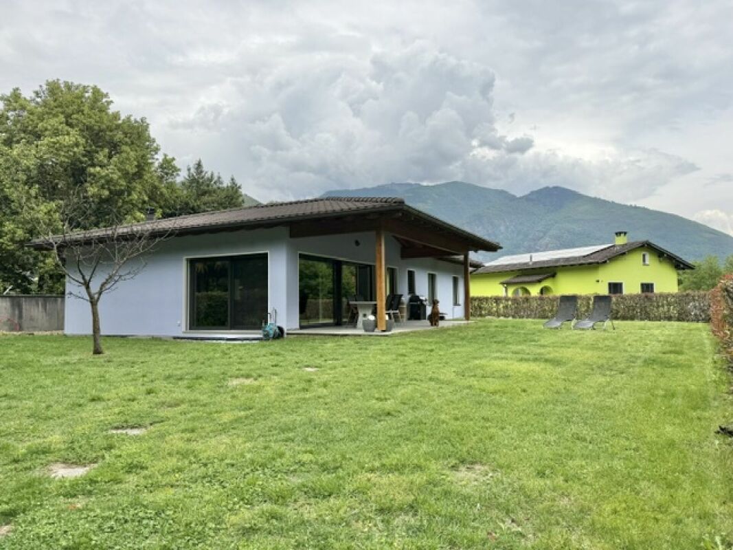 Modernes Haus mit großem Garten und Bergkulisse
