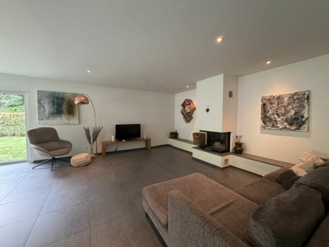 Modernes Wohnzimmer mit Kamin und Gartenblick