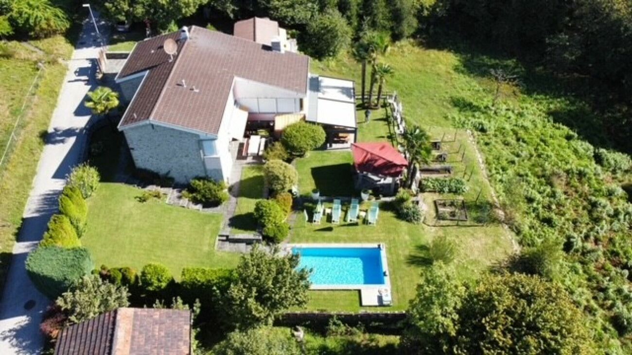 Luftaufnahme eines Einfamilienhauses mit Pool und Garten
