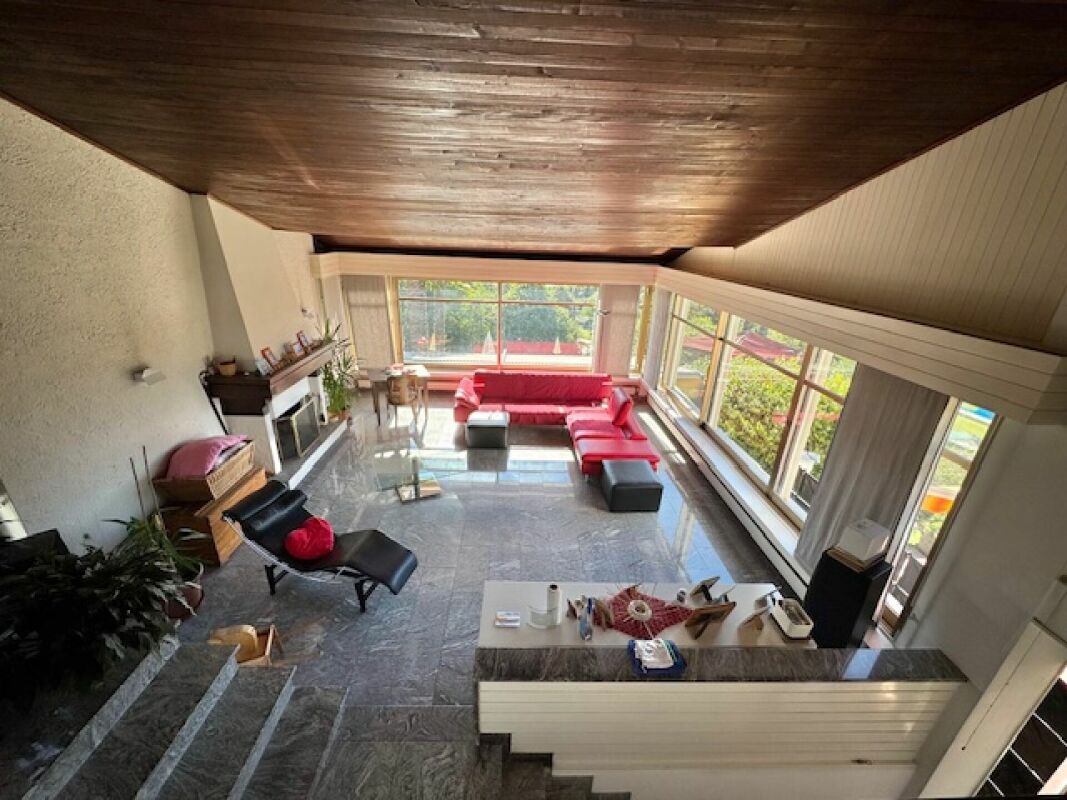 Großer Wohnraum mit Panoramafenstern und Kamin