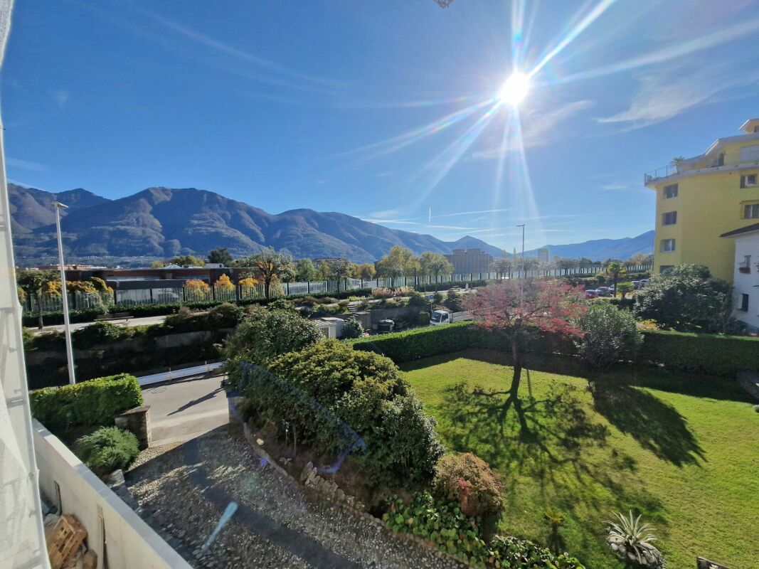 Balkon- oder Fensterblick mit Bergpanorama und Garten