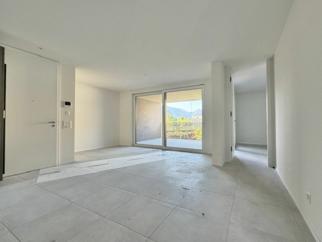 Leerer, moderner Wohnraum mit Terrassentür und Gartenblick