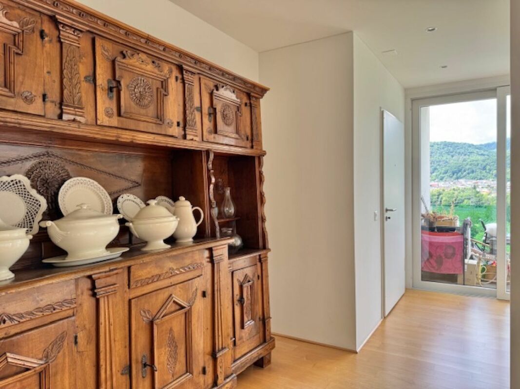 Flur mit rustikalem Holzschrank und Balkonblick