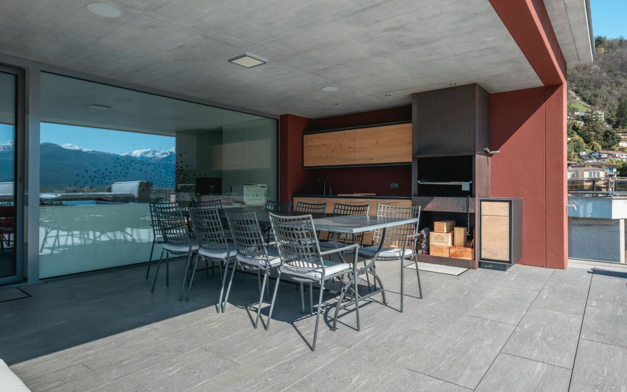Überdachte Terrasse mit Grill und Bergblick