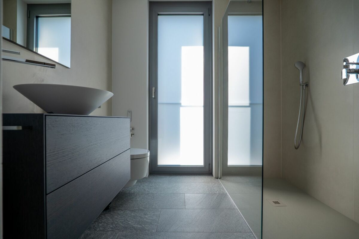 Modernes Badezimmer mit bodentiefer Dusche und Waschplatz