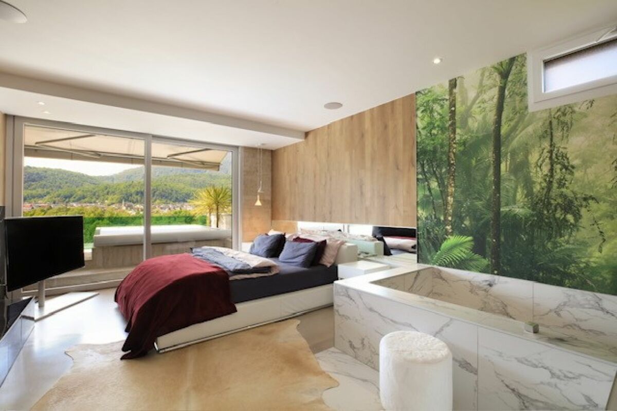 Modernes Schlafzimmer mit Badewanne und Naturblick