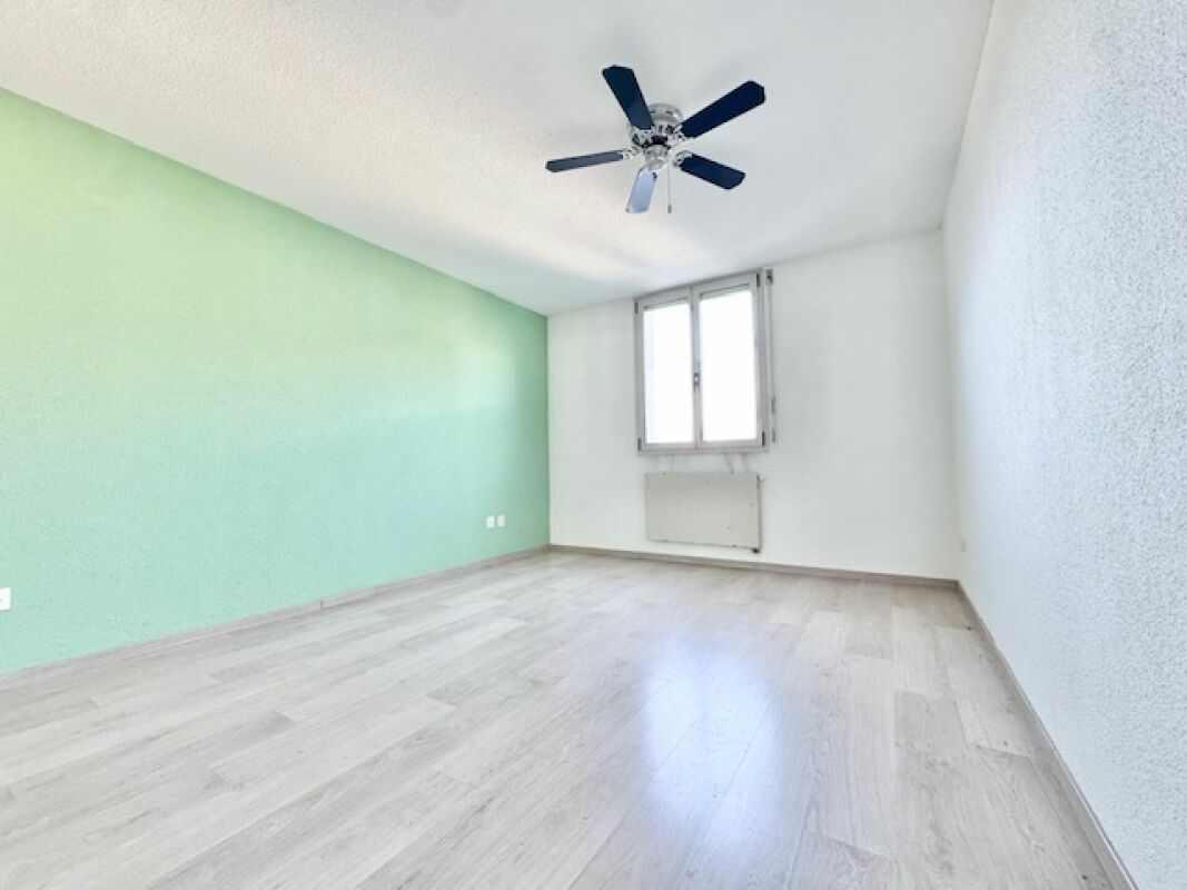 Helles, leeres Schlafzimmer mit grünem Akzent