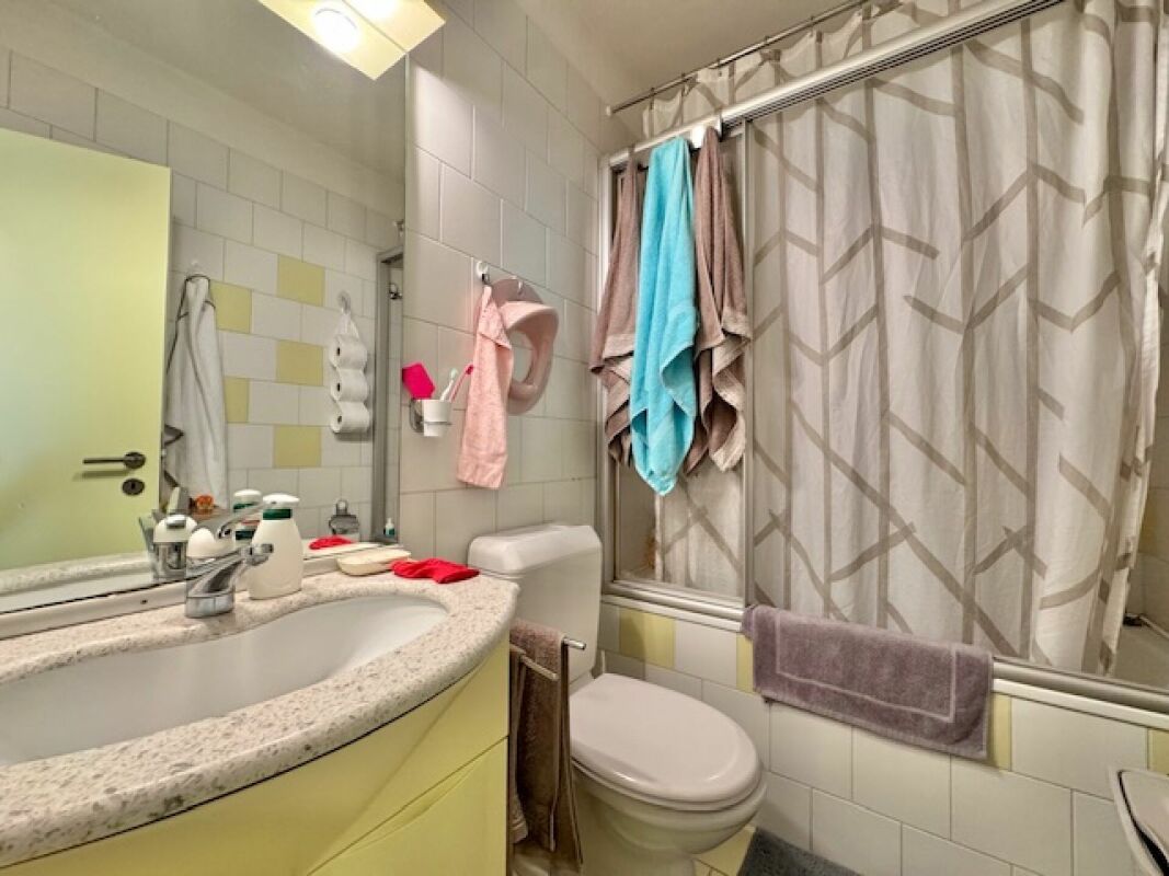 Kleines helles Badezimmer mit Badewanne und WC