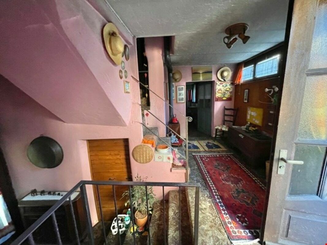 Innenbereich mit pink gestrichenen Wänden und Treppenaufgang