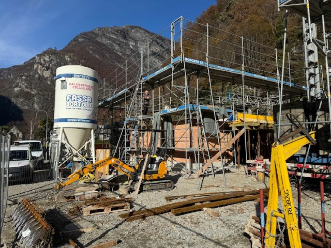 Baustelle mit Gerüst vor Bergkulisse