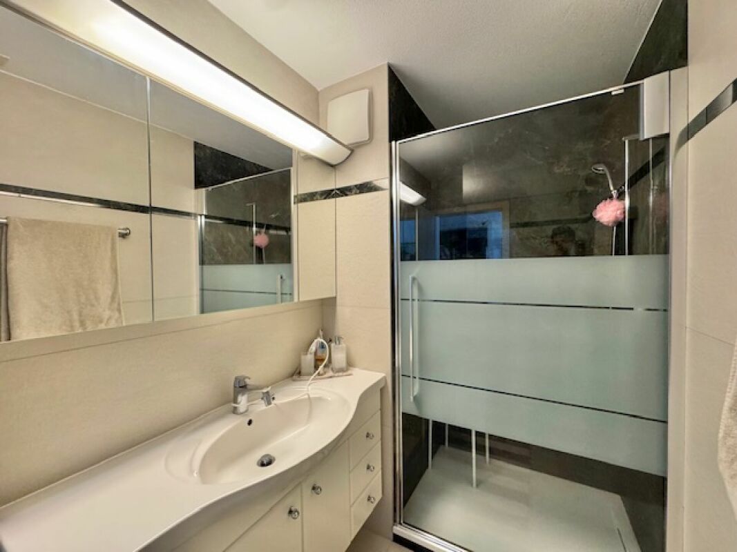 Modernes Badezimmer mit Glasdusche und Spiegelschrank