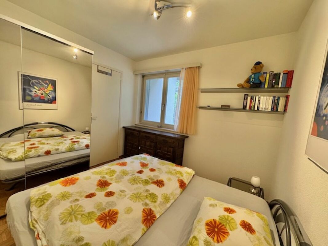 Kleines Schlafzimmer mit Doppelbett und Spiegelkleiderschrank