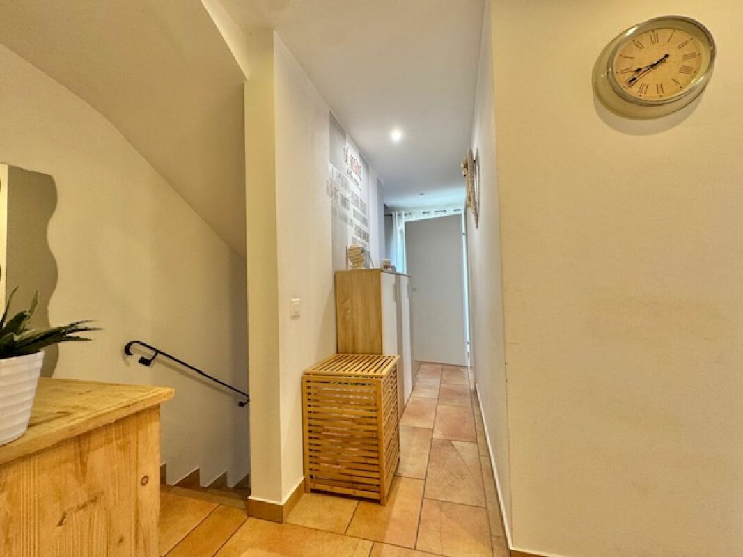 Heller Flur mit Treppe und Holzschränken