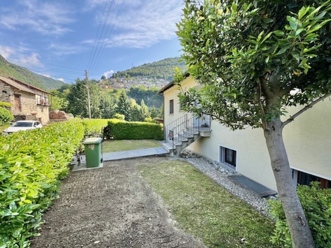 Gartenansicht eines Wohnhauses mit Bergkulisse