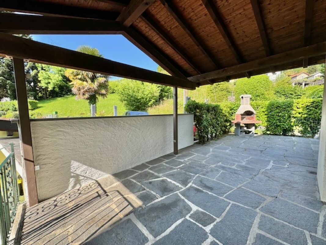Überdachte Terrasse mit Steinfußboden und Grillplatz