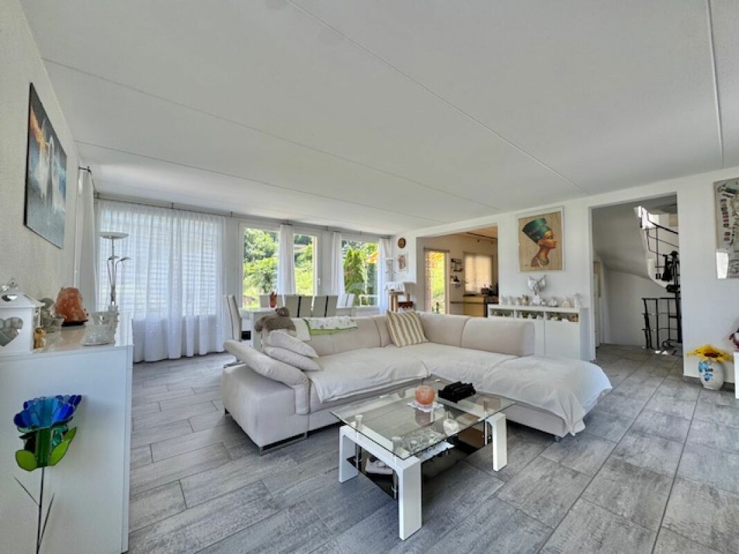 Heller Wohnbereich mit großem Sofa und Gartenblick