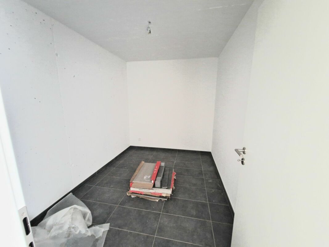 Leerer kleiner Raum mit dunklem Fliesenboden