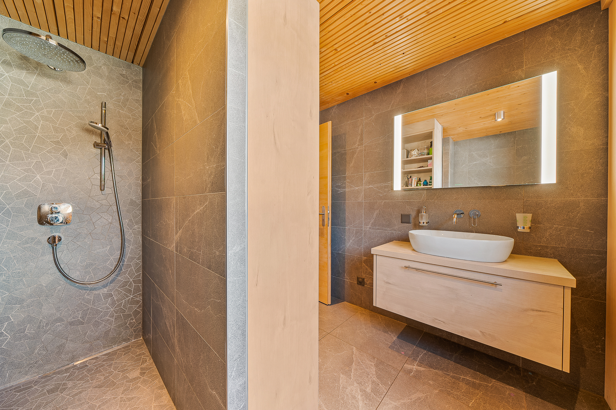 Modernes Badezimmer mit begehbarer Dusche und beleuchtetem Waschtisch