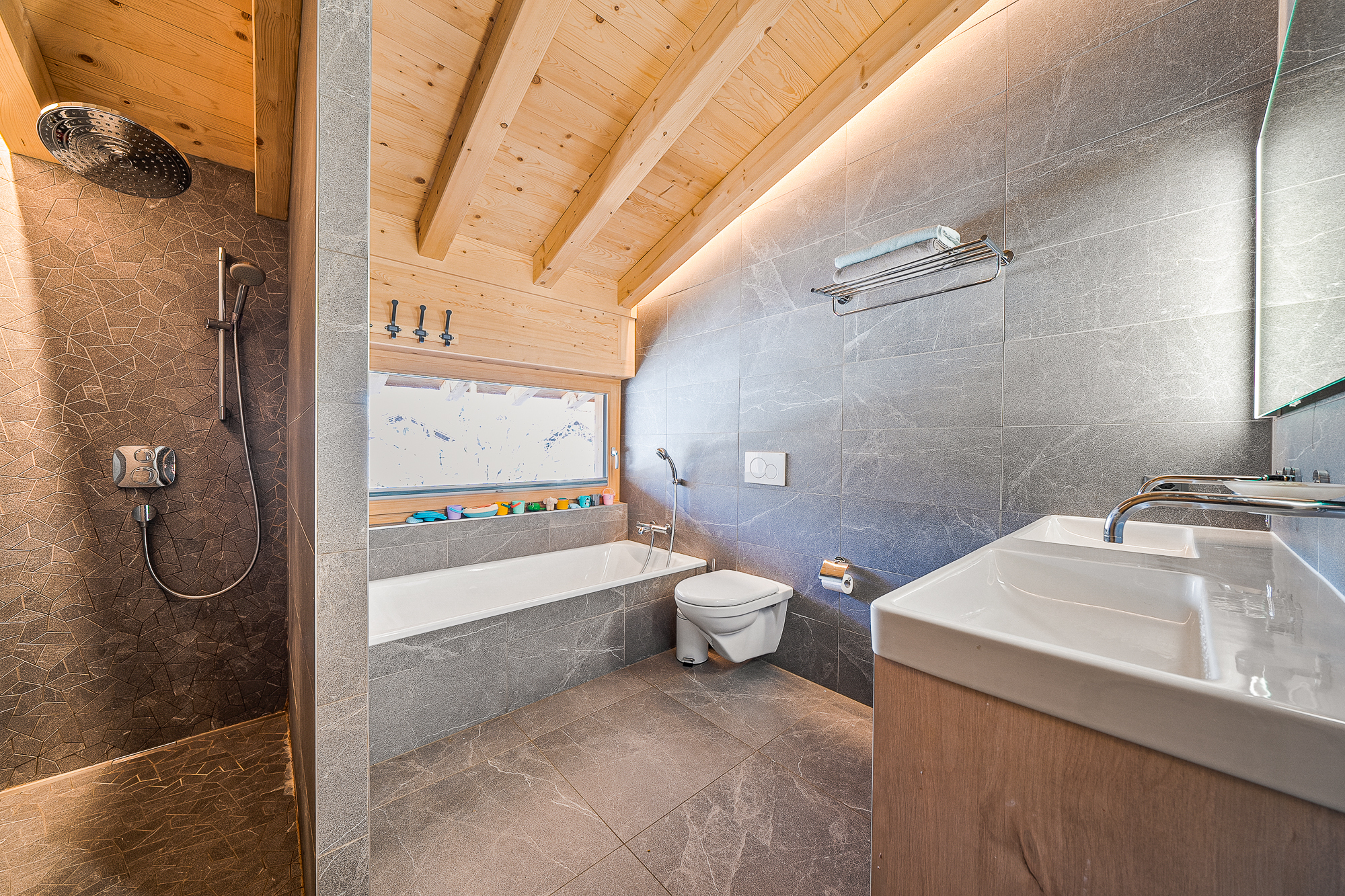 Modernes Badezimmer mit Holzdecke und Natursteinoptik