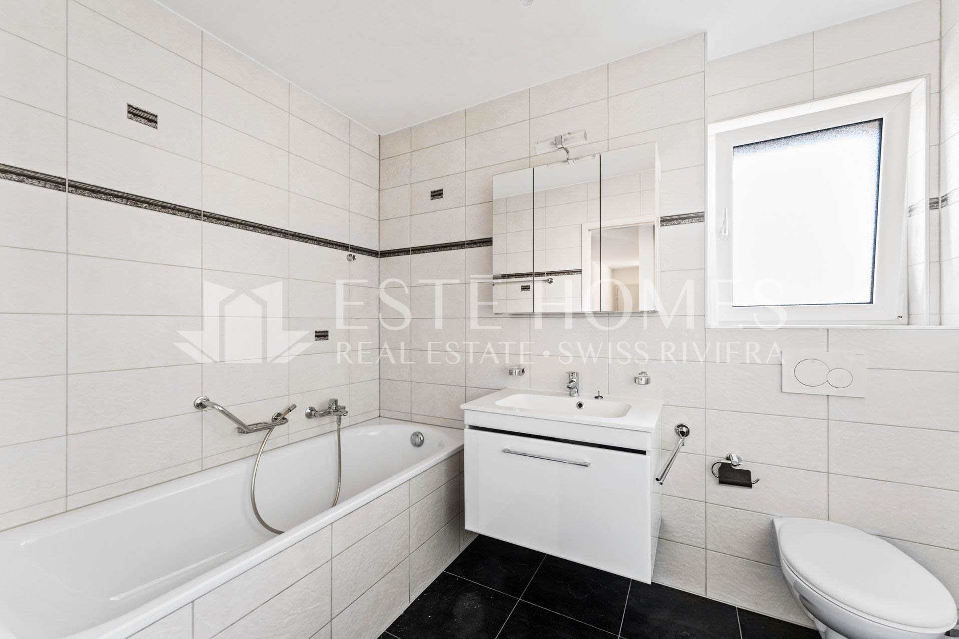 Helles, modernes Badezimmer mit Badewanne, Waschtisch und WC