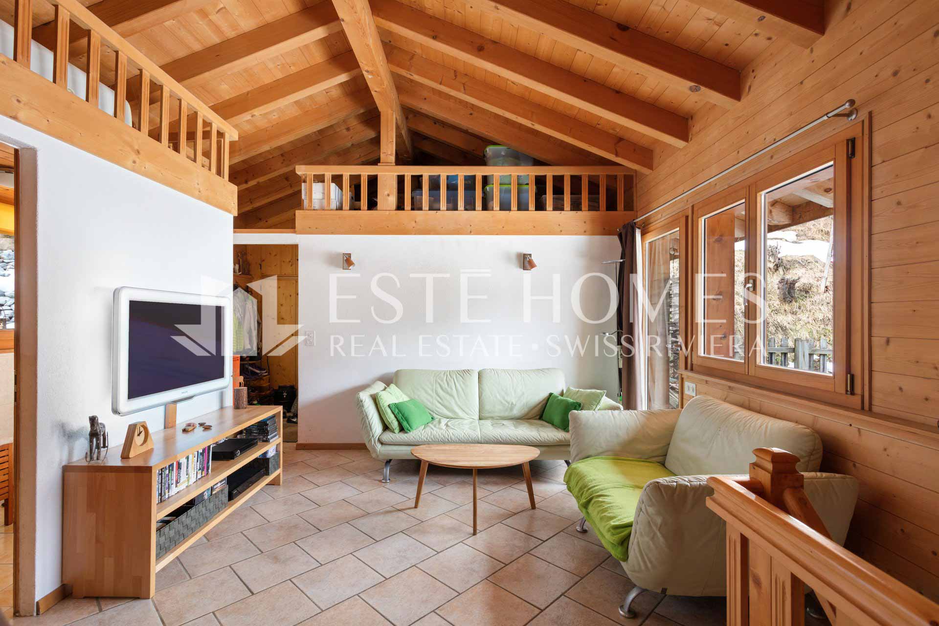 Gemütliches Wohnzimmer mit Holzverkleidung und Galerie
