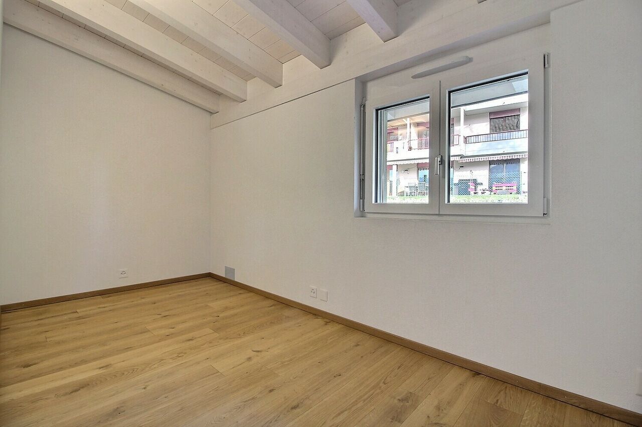 Heller leerer Raum mit Holzfußboden und Fenster